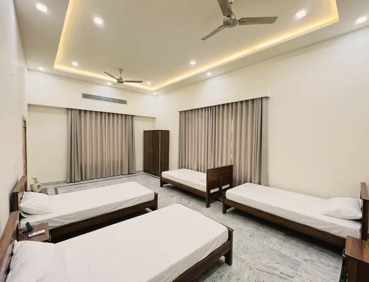 Four-bed shared room with curtains and ceiling lights